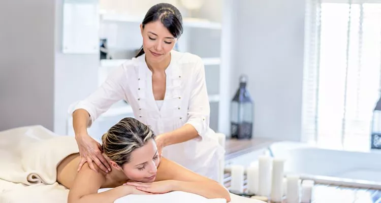 A masseuse giving a massage to a female customer.