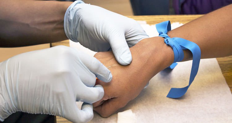 A healthcare personnel inserting a needle in a patient'f vein