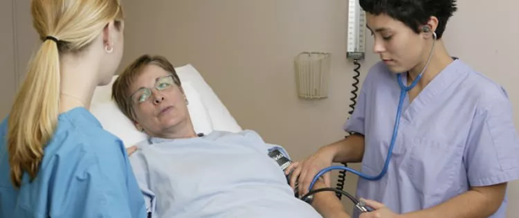 A older patient is looking at her doctor who is trying to help her remain calm and composed.