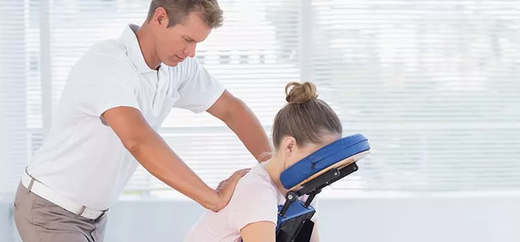 A female is receiving a massage from a male masseuse