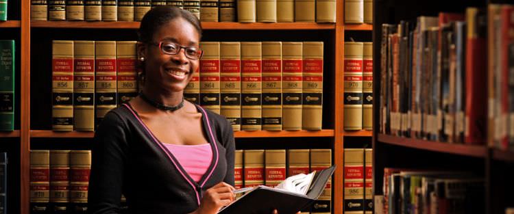 A female Paralegal Student in a law library studying