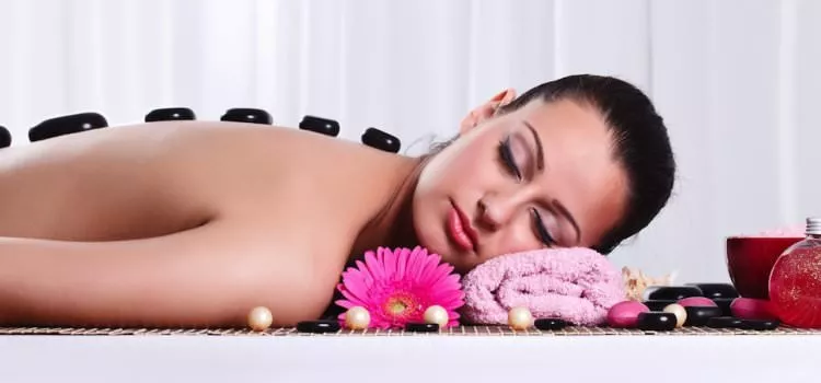 A picture of a woman receiving Hot Stone Massage therapy