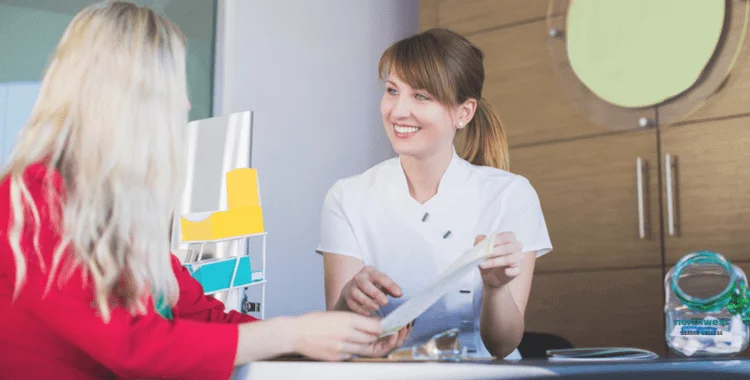 A Dental Administrative Assistant talking with client