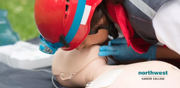 A resque worker administering mouth-to-mouth on a dummy.