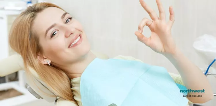 young girl in a dental office giving the "all-okay" sign