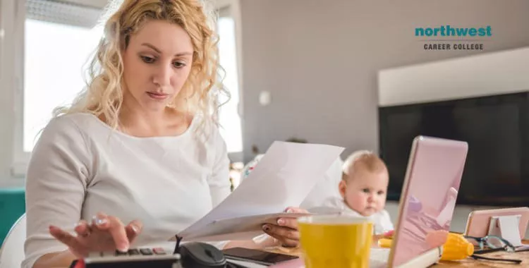 medical biller Working From Home while a baby looks at something in the distant.