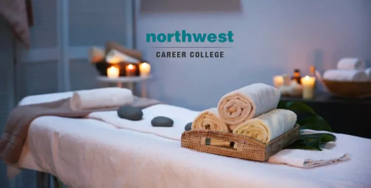 Rolled up towels and massage stones on a massage table.