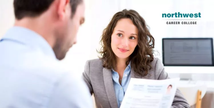 A man is interviewing a woman as she looks at him hopefully.