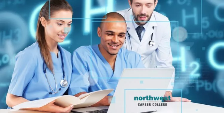 A group of people from medical field looking at computer and smiling.