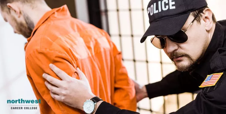 A corrections officer restraining an inmate who looks remorseful for his previous life-choices.