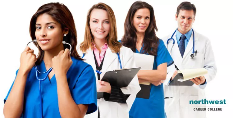 Medical Assistant standing in line in the background, while another medical assistant is smiling weirdly as she is wearing her stethoscope.