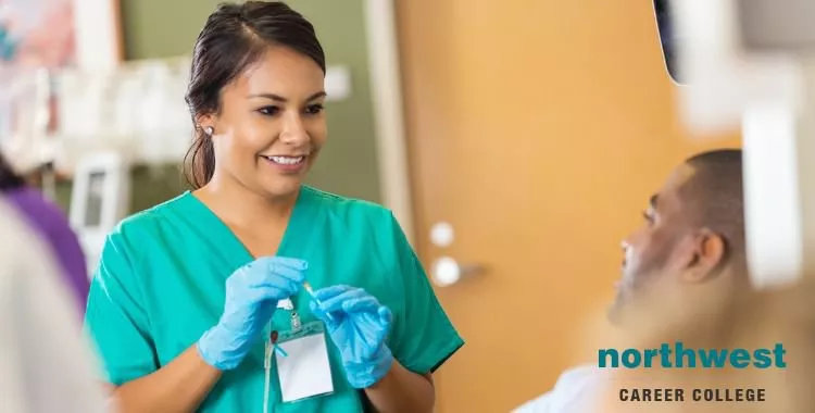 Phlebotomist preparing patient from whom she will take blood sample.