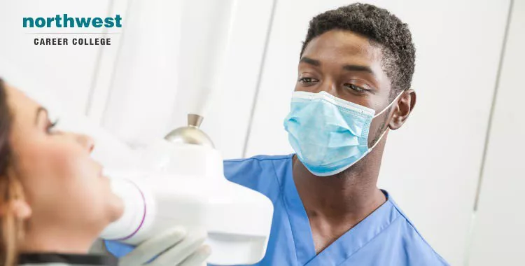 A young dentist looking at patient's teeth.