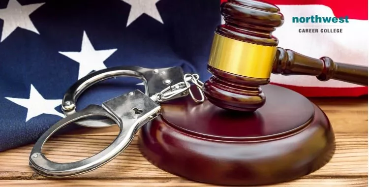 Gavel resting on a gavel-stand, handcuffs and American flag.