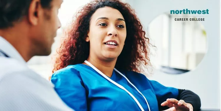 medical assistant in hospital lounge talking with a man.