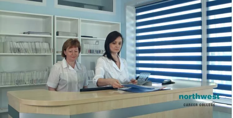 Smiling medical billing and coding person standing at the desk in hospital