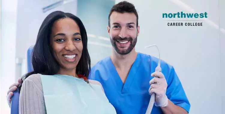 A dental assistant smiling with a woman patient