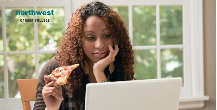 student studying and eating pizza