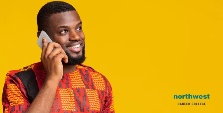 A man in a colorful shirt smiles while on the phone, representing communication in the least spoken languages.