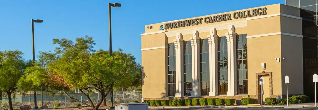 Northwest Career College building with large windows, surrounded by trees and clear blue sky.