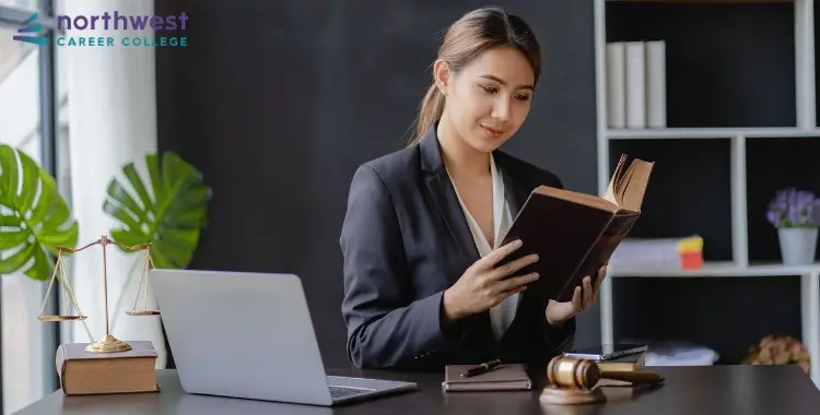 A professional woman reads a book at her desk, representing the role of a Remote Legal Assistant.