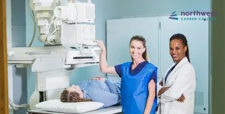 Two healthcare professionals stand beside a patient on an examination table, with medical equipment in the background.