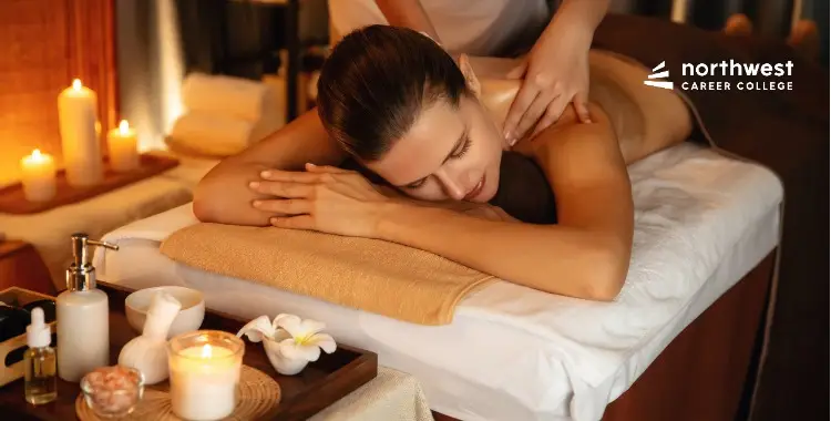 A woman receives a relaxing massage in a serene spa setting with candles and essential oils nearby.