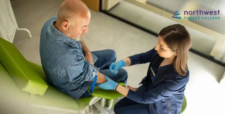 A healthcare professional prepares to draw blood from a seated male patient in a clinical setting.