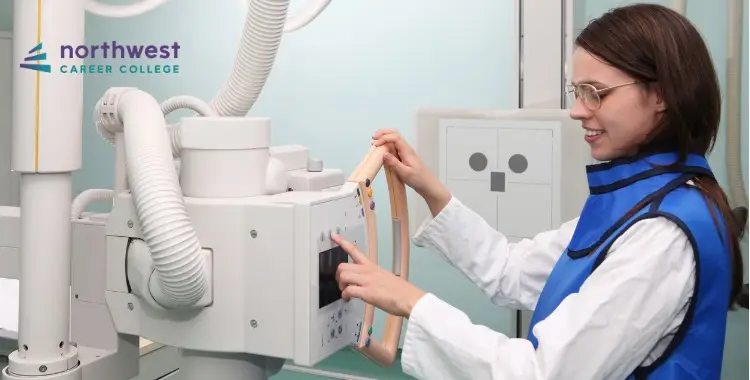 A student in a protective apron operates an X-ray machine at Northwest Career College.