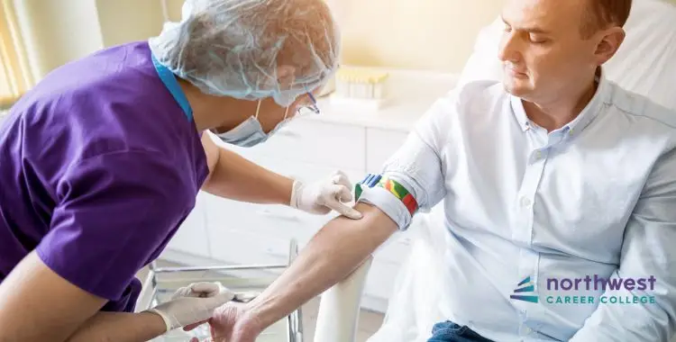 A healthcare professional prepares to draw blood from a patient in a clinical setting.