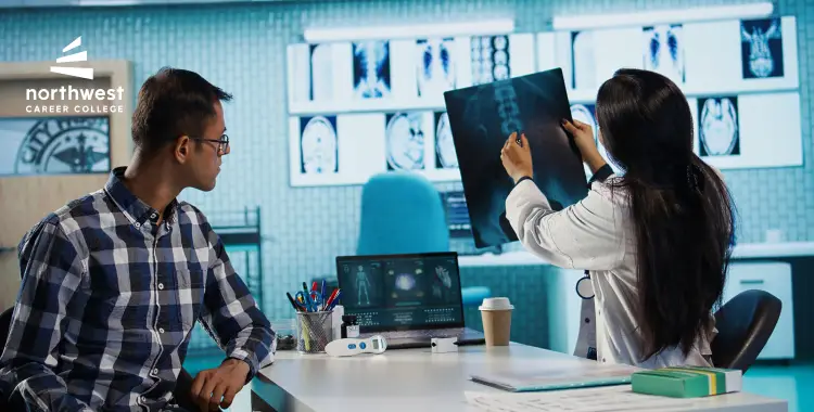 A healthcare professional shows an X-ray to a student in a modern classroom setting.