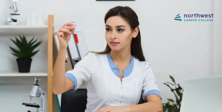 A woman in a lab coat examines a test tube with red liquid in a laboratory setting.