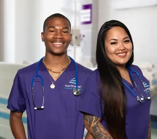 Two smiling students in scrubs with stethoscopes, representing the Medical Assistant Course at Northwest.