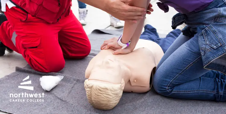 Two individuals practice CPR on a manikin during a training session at Northwest Career College.