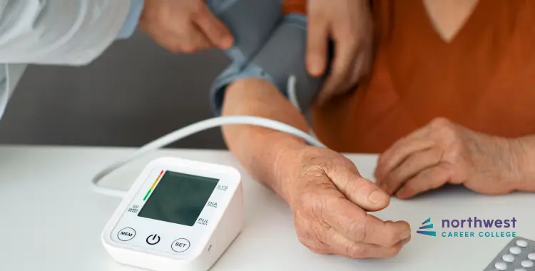 A healthcare professional measures blood pressure on a patients arm using a digital monitor.