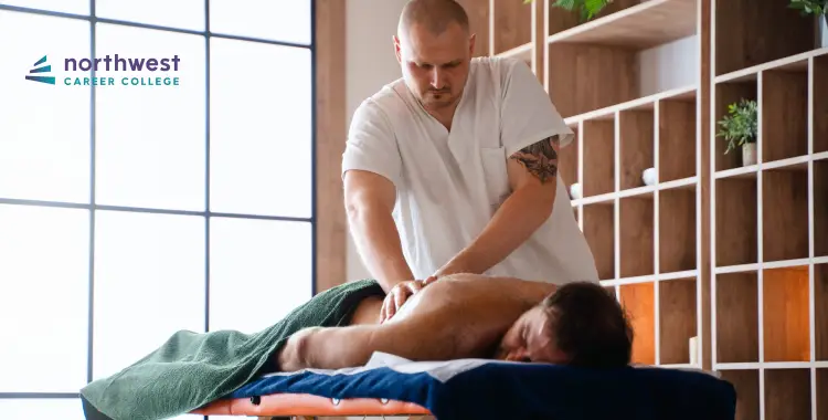 A massage therapist works on a clients back in a serene, well-lit room.
