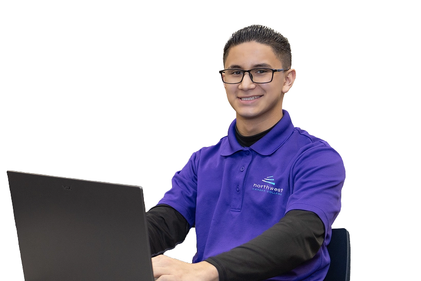 Student in a purple shirt smiles while working on a laptop, representing the information technology degree program in.