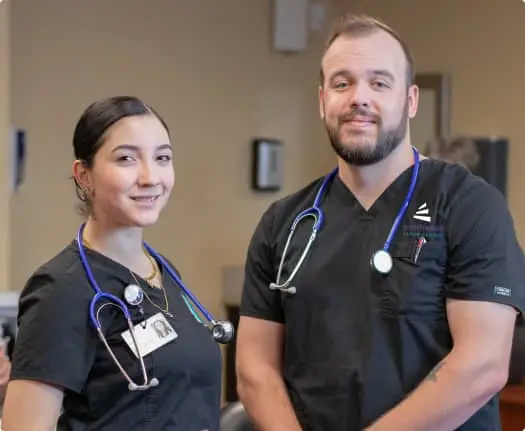 Two medical assistants in scrubs smile confidently, representing Medical Assistant Training in Henderson, Nevada.