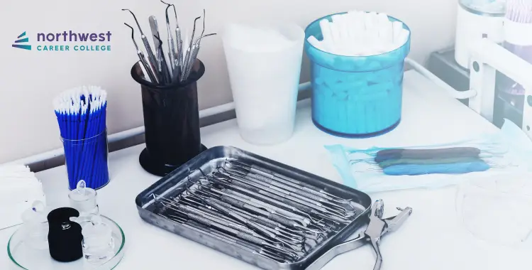 A dental workstation with various tools, cotton rolls, and disposable items organized on a table.